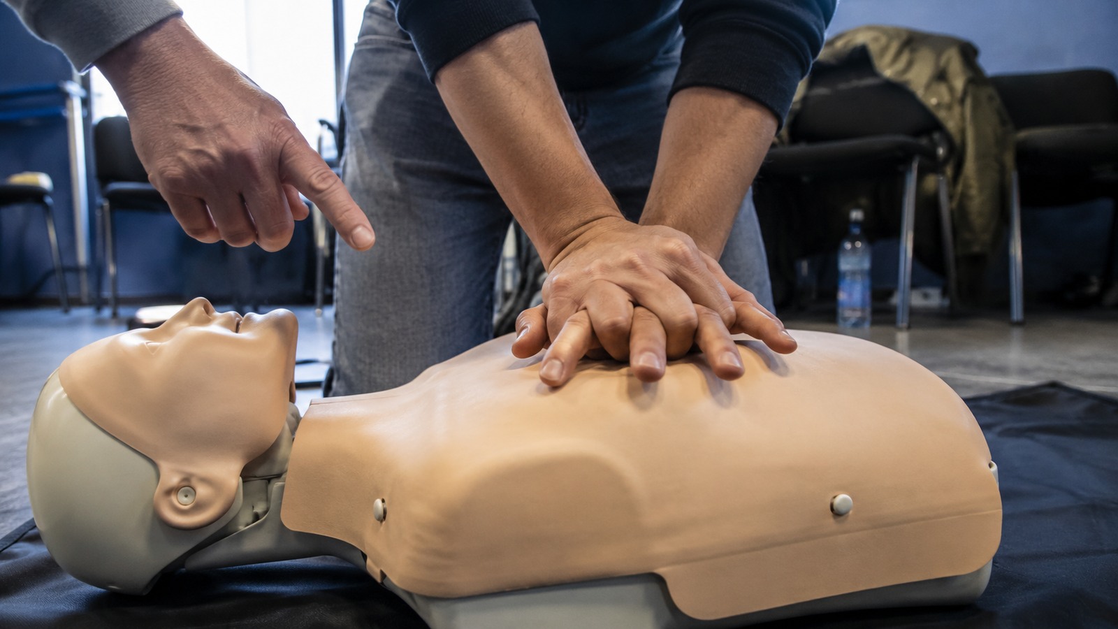 Participant care exersează compresii toracice pe manechin în timpul unui curs de prim ajutor