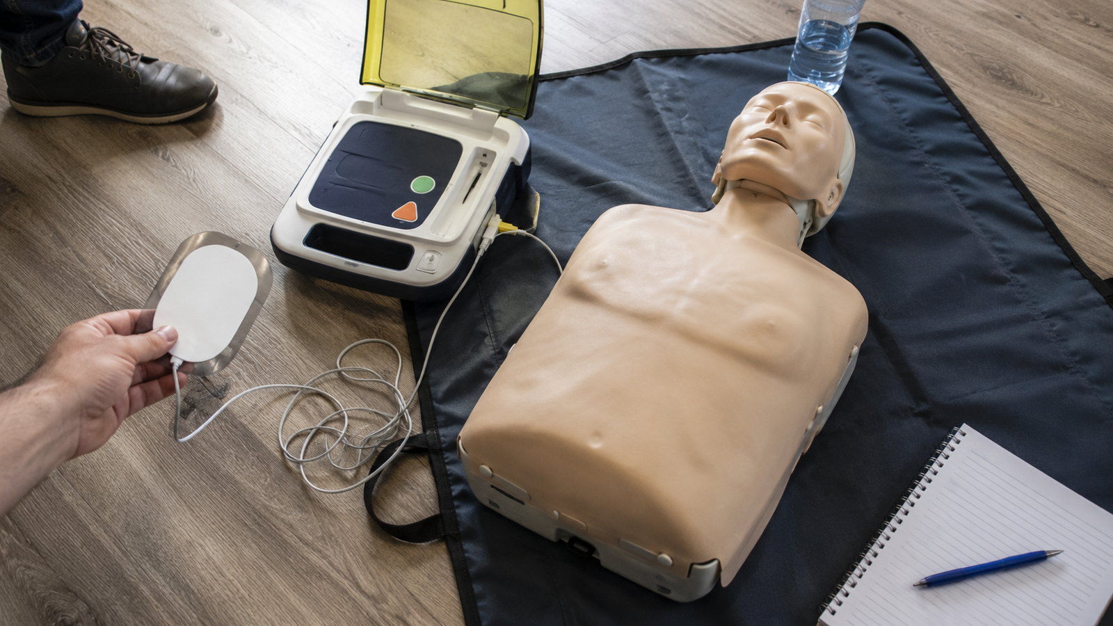 Instructor care prezintă un AED de antrenament în timpul unui curs de prim ajutor